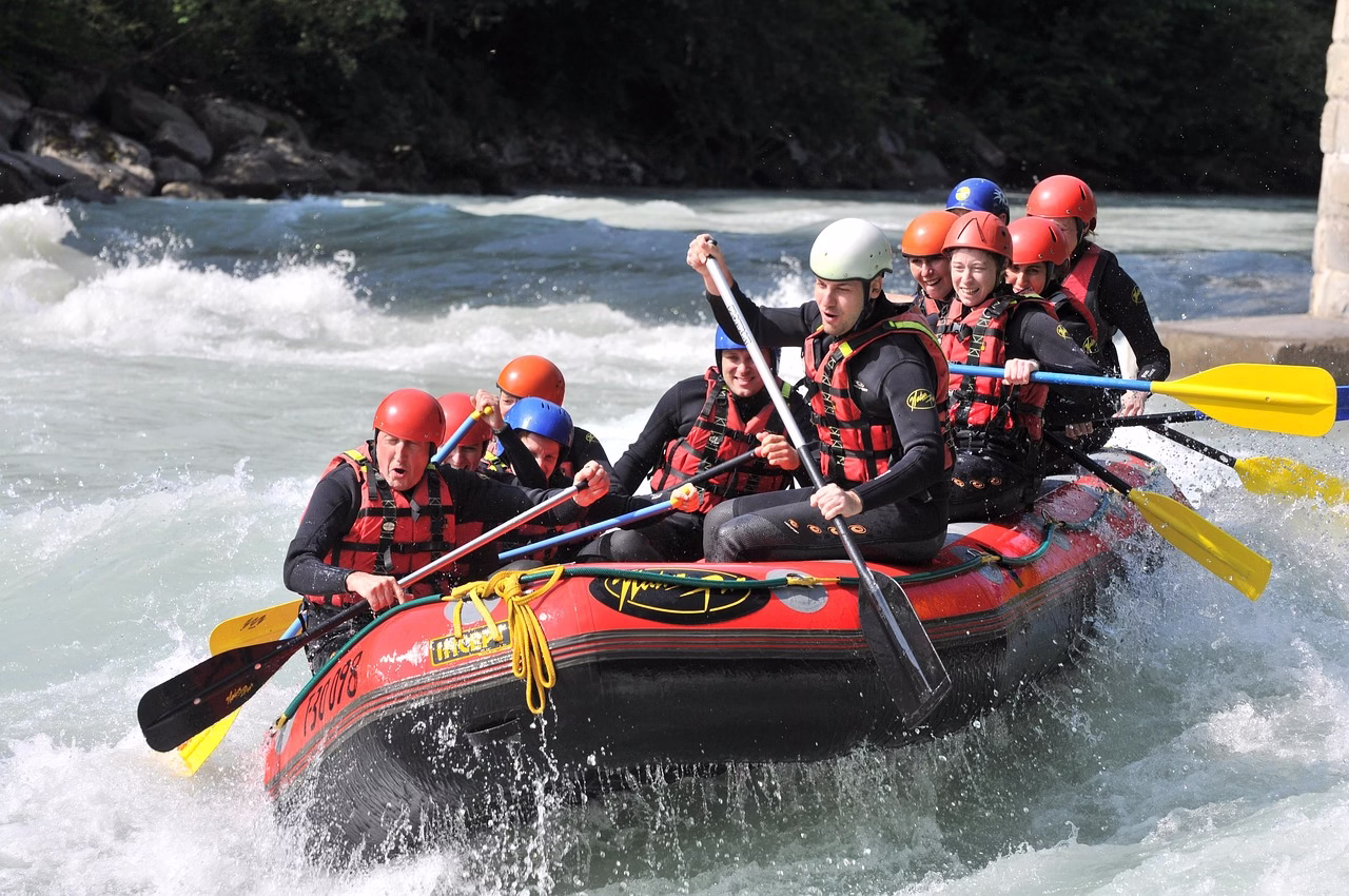 Group of rafters paddling through powerful white water rapids on the Nile River in Jinja, Uganda, surrounded by lush green scenery.