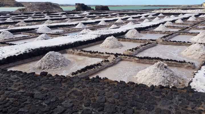 Aerial view of Lake Katwe's salt pans with local miners harvesting salt under the sun in Queen Elizabeth National Park, Uganda.