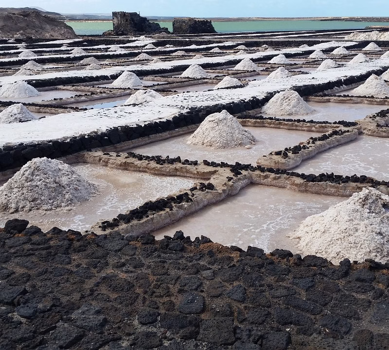 Aerial view of Lake Katwe's salt pans with local miners harvesting salt under the sun in Queen Elizabeth National Park, Uganda.